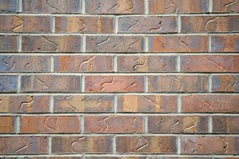 A red brick wall with decorative marks carved into the bricks Stock Photos