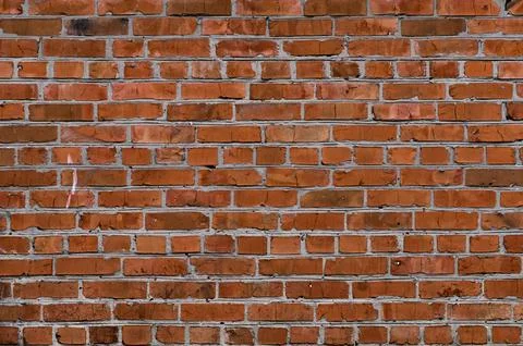 Red brick wall forms textured abstract background with rustic masonry pattern. Foto stock