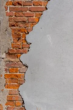 A red brick wall half covered with plaster. Stock Photos