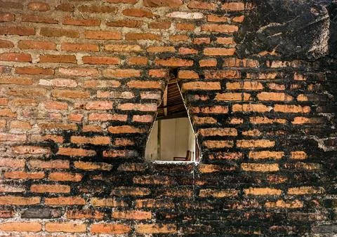 Red brick wall with a hole Stock Photos