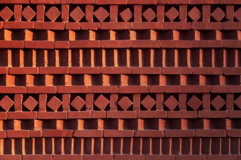 Red brick wall with ornamental pattern in shadow and light gradient Stock-Fotos