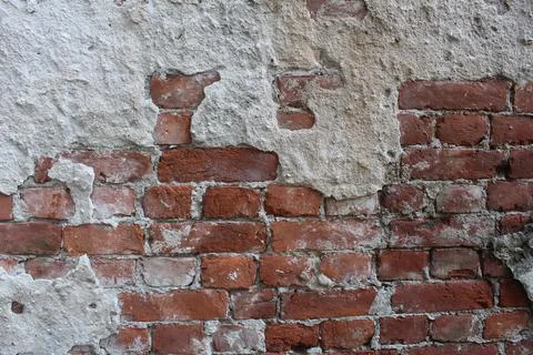 Red brick wall with remnants of cement, cement, mortar. Brutal construction b Stock Photos