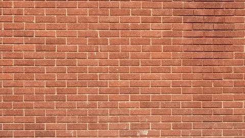Red brick wall with a rough texture and classic architectural style. Stock Photos