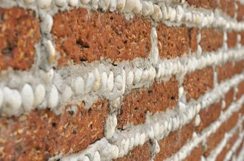 Red brick wall with small white rocks. 库存照片