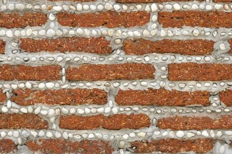 Red brick wall with small white rocks. Foto stock