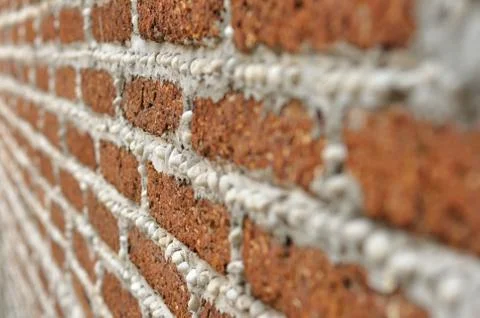 Red brick wall with small white rocks. Stock Photos