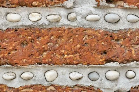 Red brick wall with small white rocks. Stock Photos