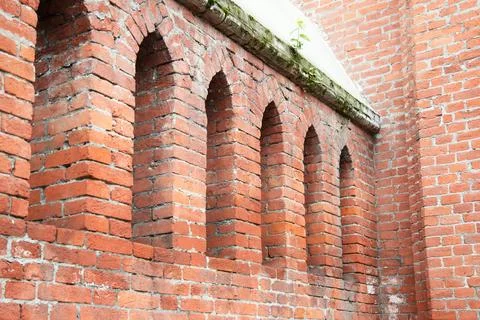 Red brick wall with the small window of the old tower. Old arch arc niche  .. Stock Photos