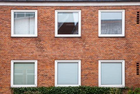 Red brick wall with square windows Stock Photos