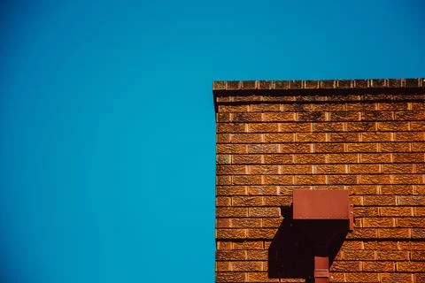 Red Brick Wall In Strong Sunlight Against A Clear Blue Sky Stock Photos