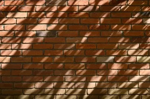 Red brick wall texture with diagonal light and shadow pattern background Stock-Fotos