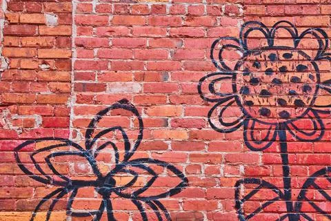 Red brick wall texture with simple black flower artwork Stock Photos
