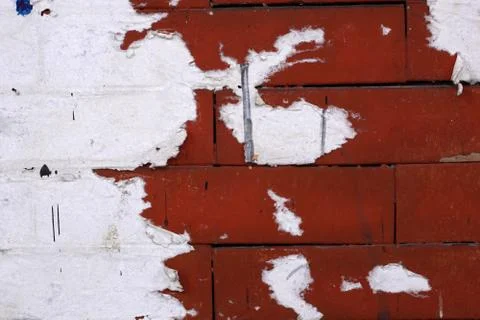 Red brick wall texture with torn posters. Stock Photos