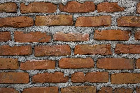 Red brick wall with thick layers of light cement. rough wall surface. dirt st Stock Photos