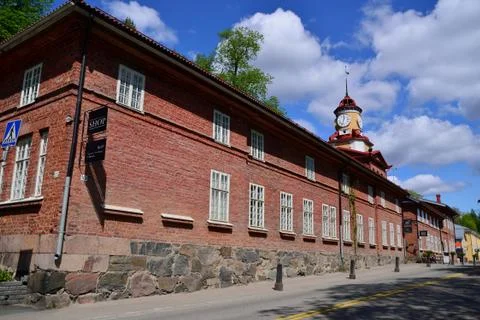 A red brick warehouse with an old clock in Fiskars, Finland. Stock Photos