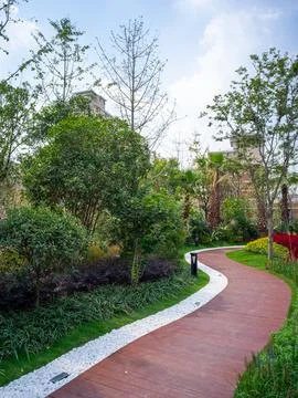 Red brick winding path in a green park - Journey concept Stock Photos