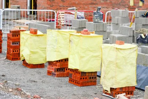 Red bricks and concrete blocks delivered on construction site and placed next Stock Photos