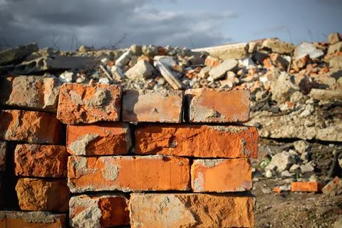 Red bricks on the background of a destroyed building and blue sky. Concept of Stock Photos