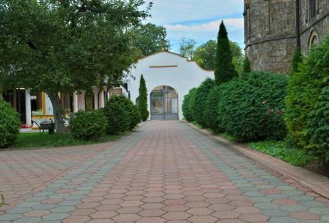 Red bricks sidewalk leading to gate in Serbian monastery Stock Photos