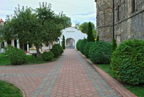 Red bricks sidewalk leading to gate in Serbian monastery Stock Photos
