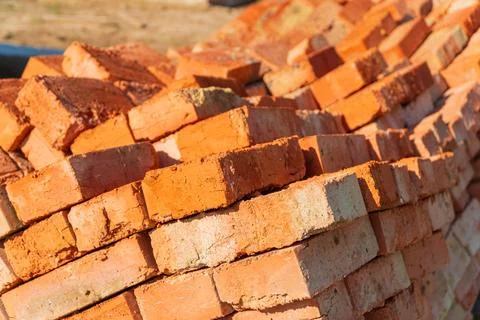 The red bricks is stacked on the construction site. Material for construction. Stock Photos