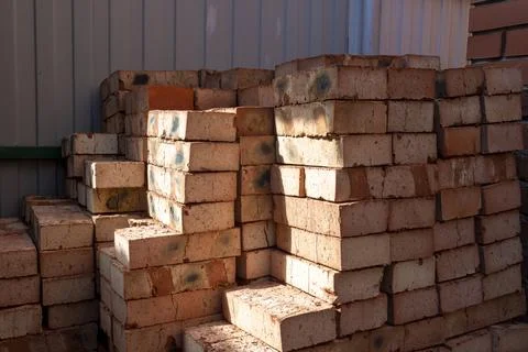 Red bricks stacked on a construction site close-up. Building stone prepared.. Stockfoto's