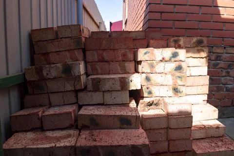 Red bricks stacked on a construction site close-up. Building stone prepared.. Stockfoto's