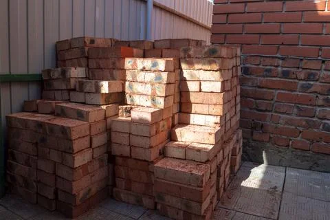 Red bricks stacked on a construction site close-up. Building stone prepared.. Stockfoto's