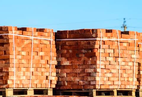 Red bricks stacked into cubes. Warehouse bricks. Storage brickworks products Stock Photos
