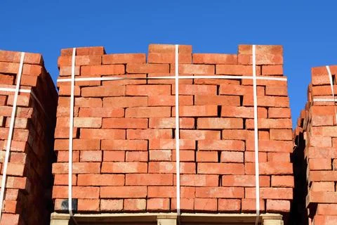 Red bricks stacked into cubes. Warehouse bricks. Storage brickworks produc... Stockfoto's