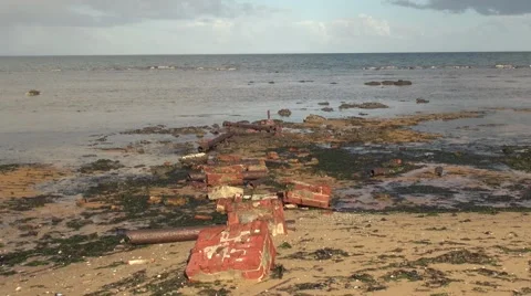 Red bricks washed ashore a sandy beach in Australia Stock Footage 50415931