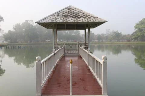 Red bridge connect between white pavilion in mash and land Foto stock