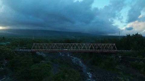 Red bridge spans river beneath stormy sky Vídeos de archivo 333330374