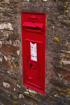 Red british postbox in brick wall Stock Photos