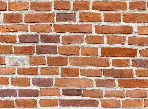 Red, brown background of uneven brickwork with lines of cement joints. Stock Photos