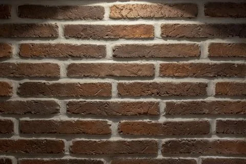 Red-brown brick wall with light cement with a spot of bright light  and shado Stock Photos