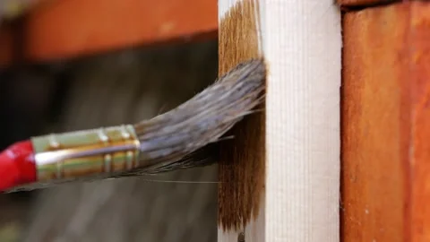 Red brush dipped in dark brown paint color makes trail of paint on soft wood Stock Footage 156693039