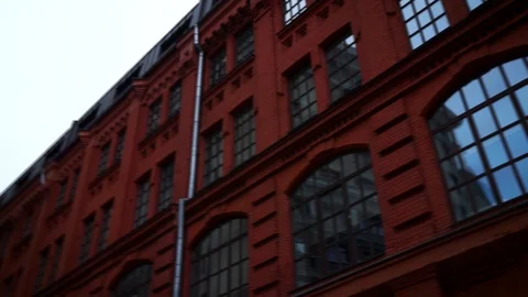 A red building with a chimney with cloudy sky. Footage. Bottom view of the 動画素材 129087302