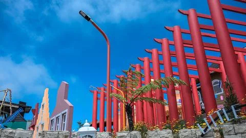 A red building with a green tree in front of it Stock Photos