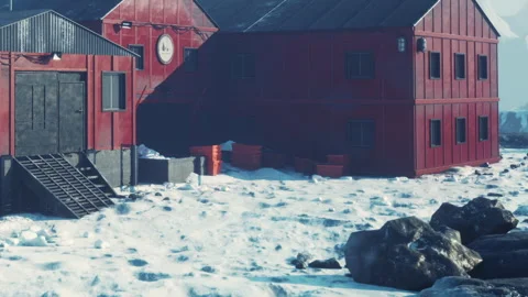 Red building on snow covered ground with rocks in the foreground and clear sky Stock Footage 339504318