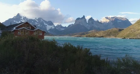 Red Building with Snow Covered Mountains and Lake ‚ Torres Del Paine Chile Stock Footage 103739079