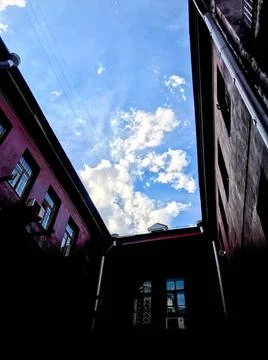 Red buildings, a cozy courtyard. a rectangular gap into which the sky is visi 写真素材
