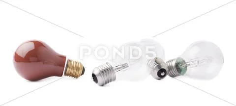 Red bulb lying next to couple of transparent bulbs over white isolated Stock Photos