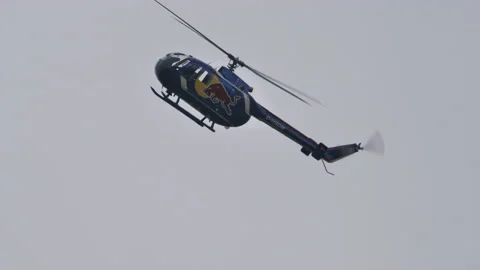 Red bull helicopter do rolling maneuver in the sky Stock Footage 167338194