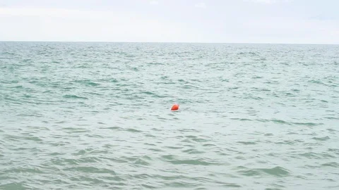 A red buoy on a desert sea swaying on waves slow motion slow motion Stock Footage