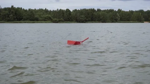 Red buoy with handle sways in course of river near forest bank. Vidéo 212712288