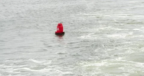 Red buoy marks navigation channel in coastal waters Stock Footage 281816619