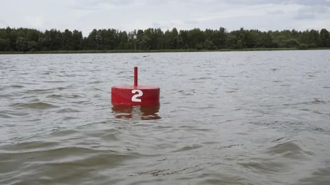 Red buoy swings on stream of deep river on cloudy day. Stock Footage 210877554
