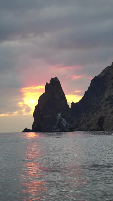 A red burning sunset over sea with rocky volcanic cliff. Abstract nature summer Stock Footage 252727485
