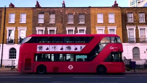 Red bus leaving busstop wide shot background houses road traffic Video stock 146338155